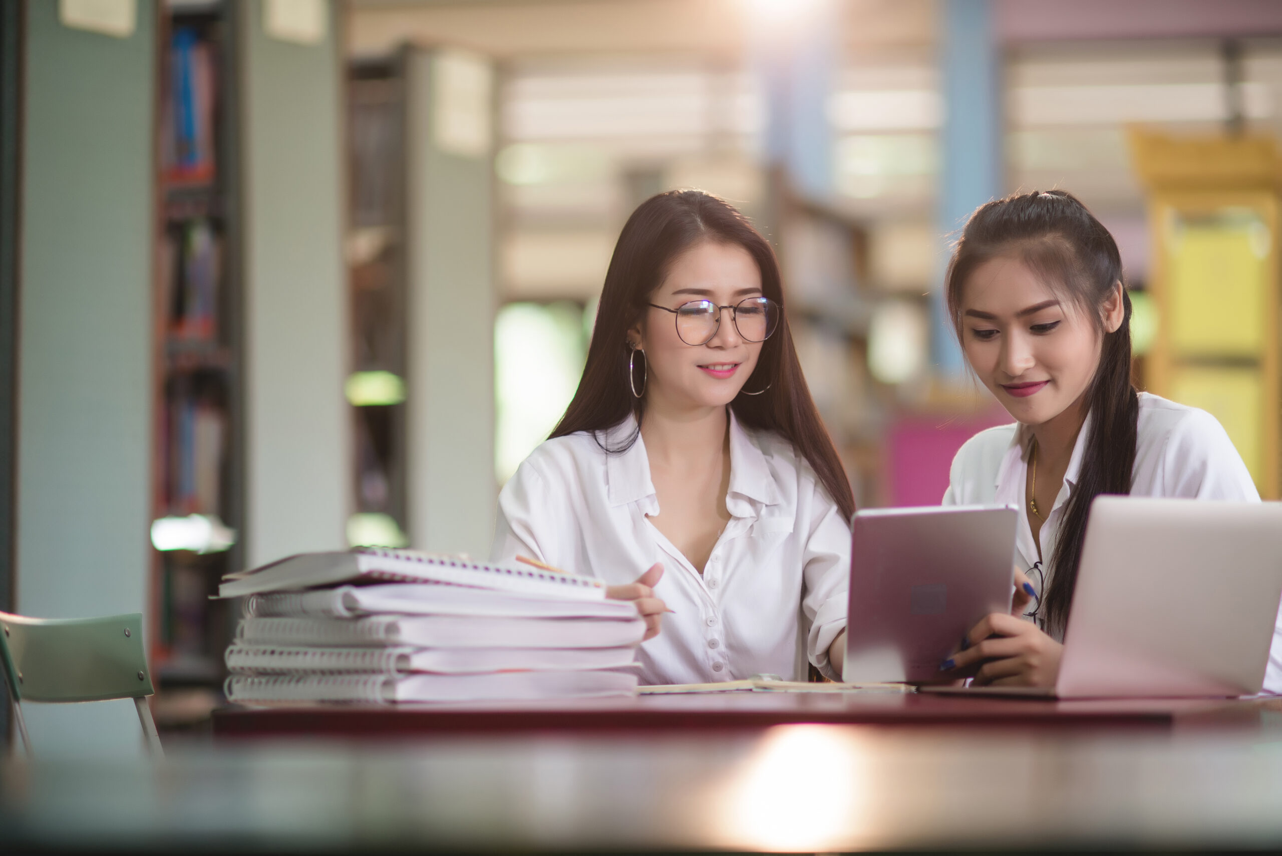 Young students learning,library bookshelves on background